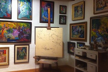lots of paintings on the wall in a museum