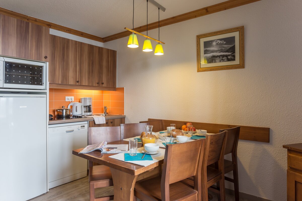 A kitchen with a table and chairs and a picture on the wall