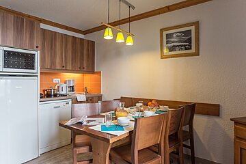 A kitchen with a table and chairs and a picture on the wall