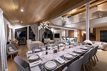 A long dining table with plates and utensils on it
