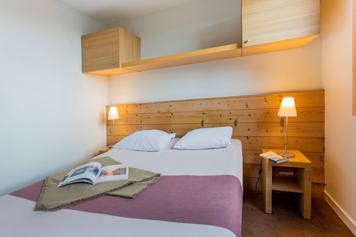 A bedroom with two beds and a book on the bed