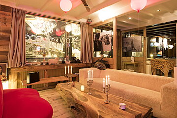 A living room with a couch and candles in front of a window that says home & work