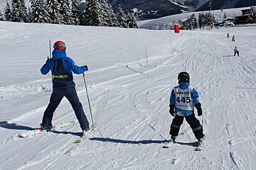 an instructor with a child on the piste