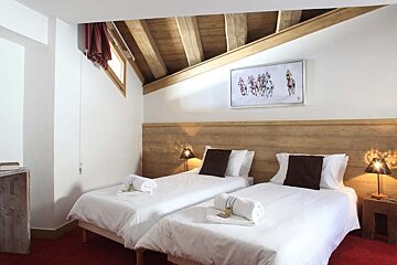A bedroom with two beds and a picture of horses on the wall