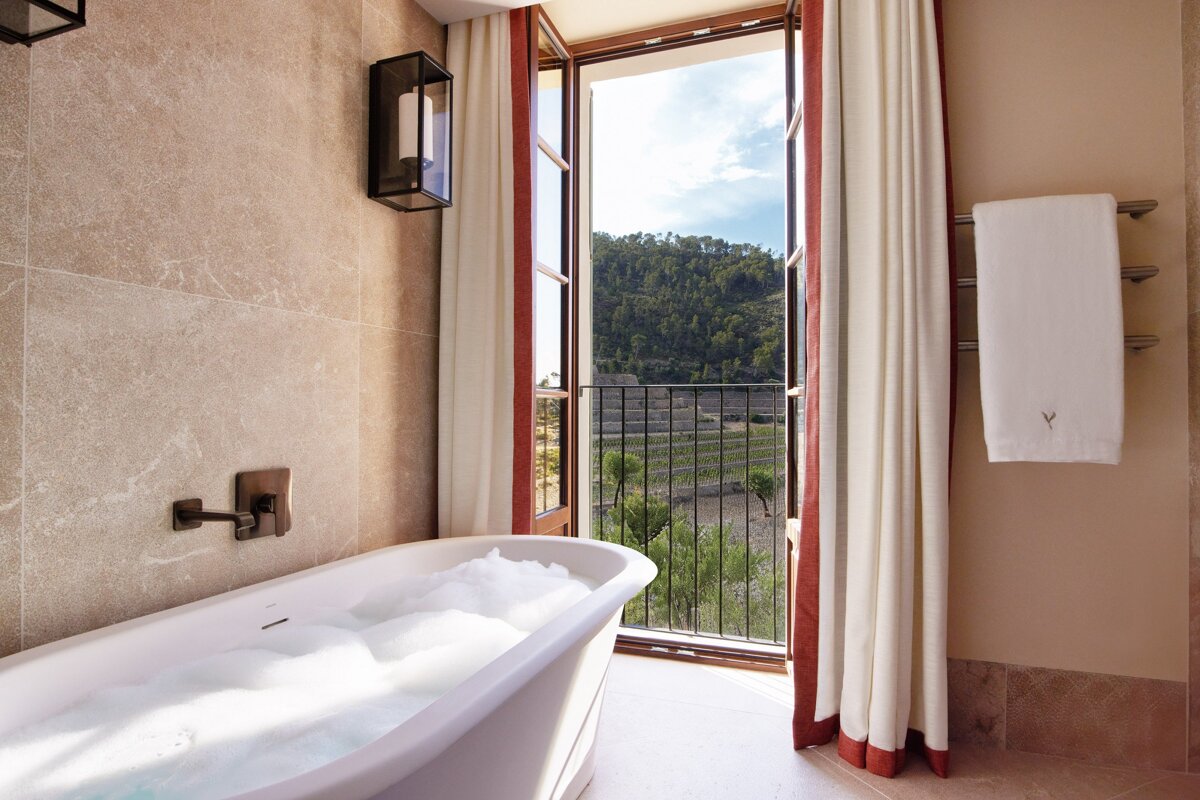 A bathtub in a bathroom with the letter v on the towel
