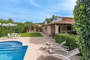 The backyard of a house with a swimming pool and chairs