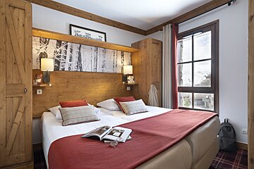 A hotel room with a bed and a book on it