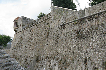 A stone wall with a tower on top of it