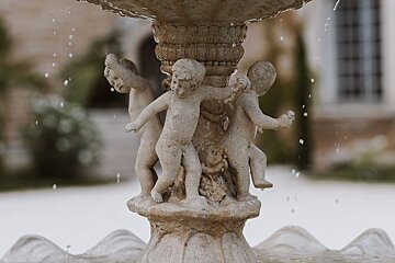 A fountain with a statue of cherubs on it
