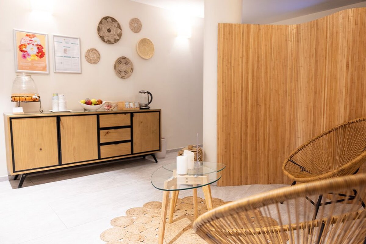 A room with wicker chairs and a wooden cabinet