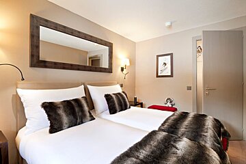 A bedroom with two beds and a large mirror