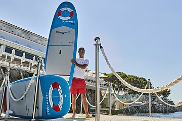 A man holding a surfboard that says performer on it
