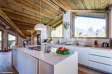 A kitchen with white cabinets and a bowl of fruit on the counter