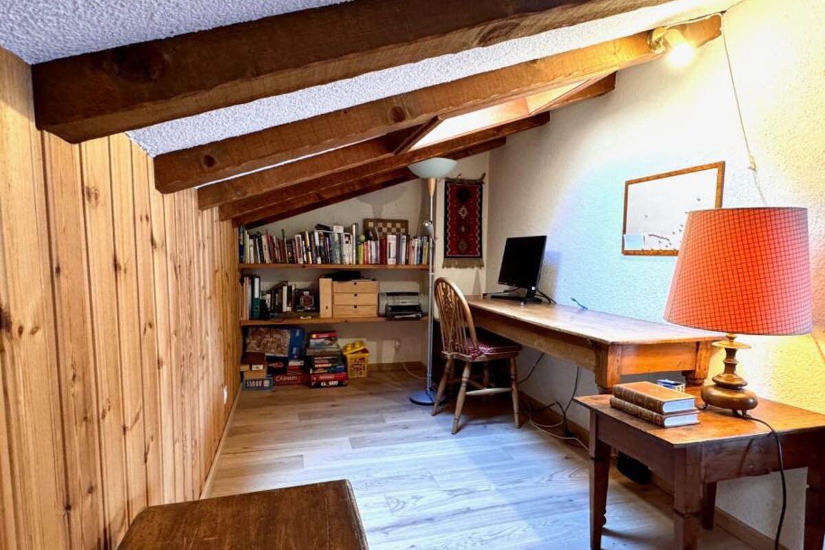 A corner of a room with a desk and a lamp