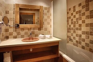 A bathroom with a sink a mirror and a bathtub