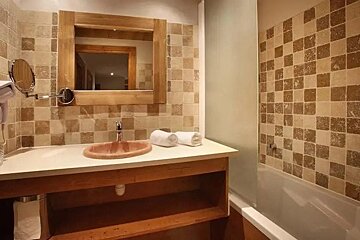 A bathroom with a sink , mirror and bathtub