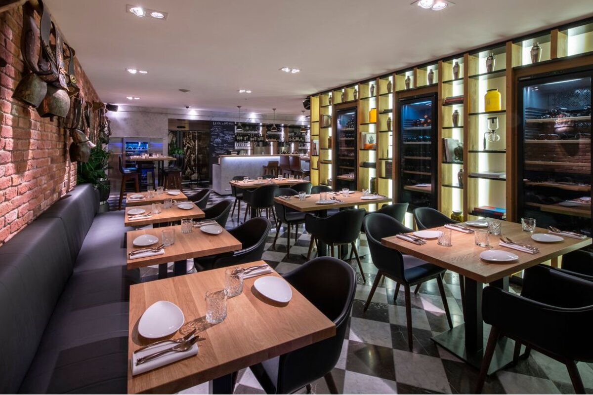A restaurant with tables and chairs and a checkered floor
