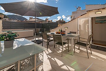 A patio with a table and chairs under an umbrella