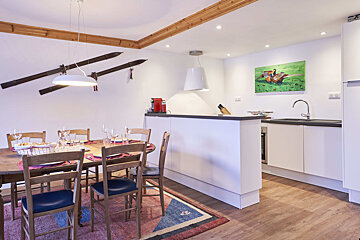 A dining room with a table and chairs and skis on the wall