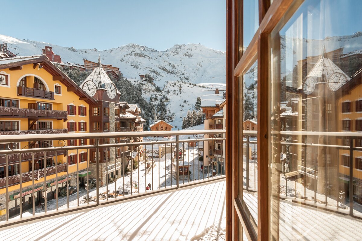 A balcony with a view of a snowy mountain town