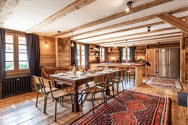 A dining room with a long table and chairs