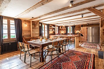 A dining room with a long table and chairs