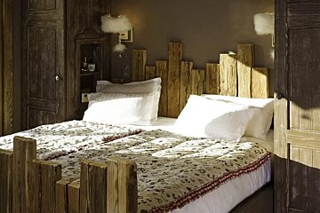 A bed with a wooden headboard and white sheets