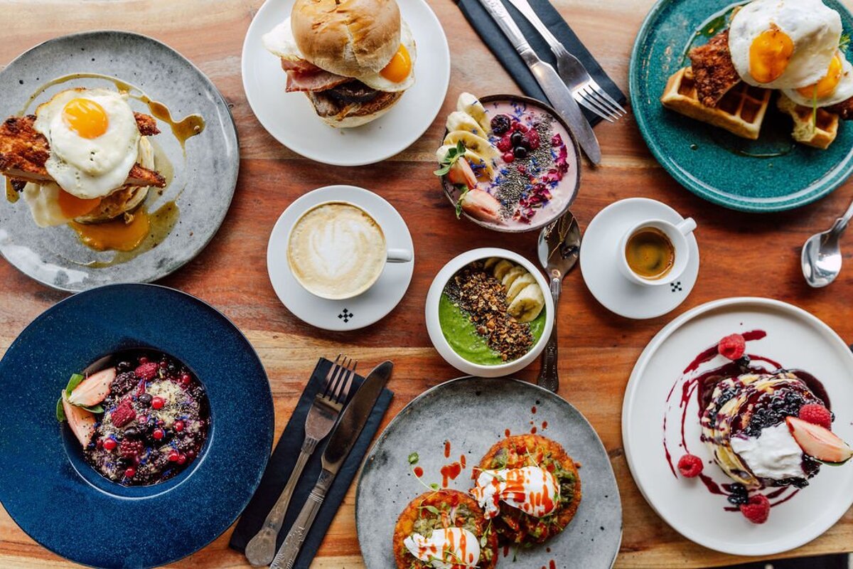 A table topped with plates of food and coffee