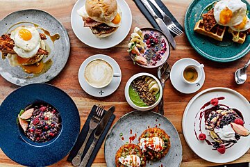 A table topped with plates of food and coffee