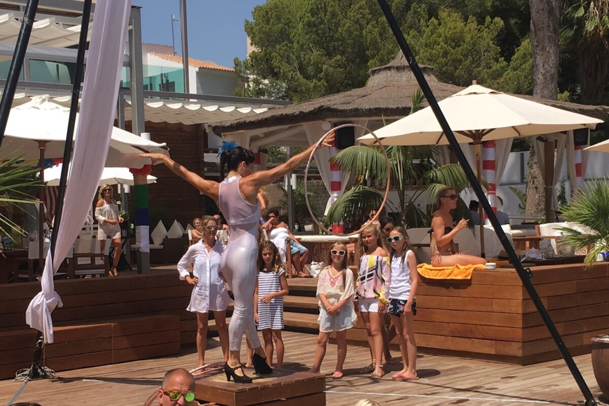 a girl performing tricks with a hoola hoop at nikki beach mallorca
