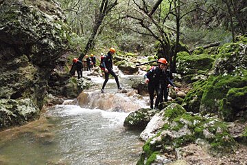 A group of people are walking across a river