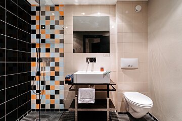 A bathroom with a sink toilet and shower