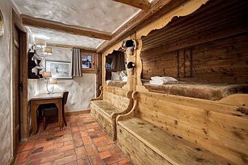 A wooden room with two beds and a desk
