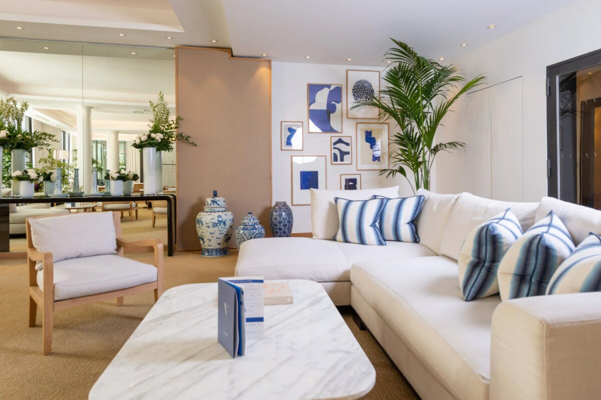 A living room with a white couch and blue and white pillows