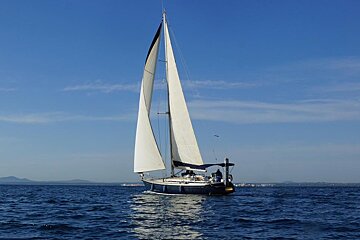 A sailboat is floating on top of a body of water