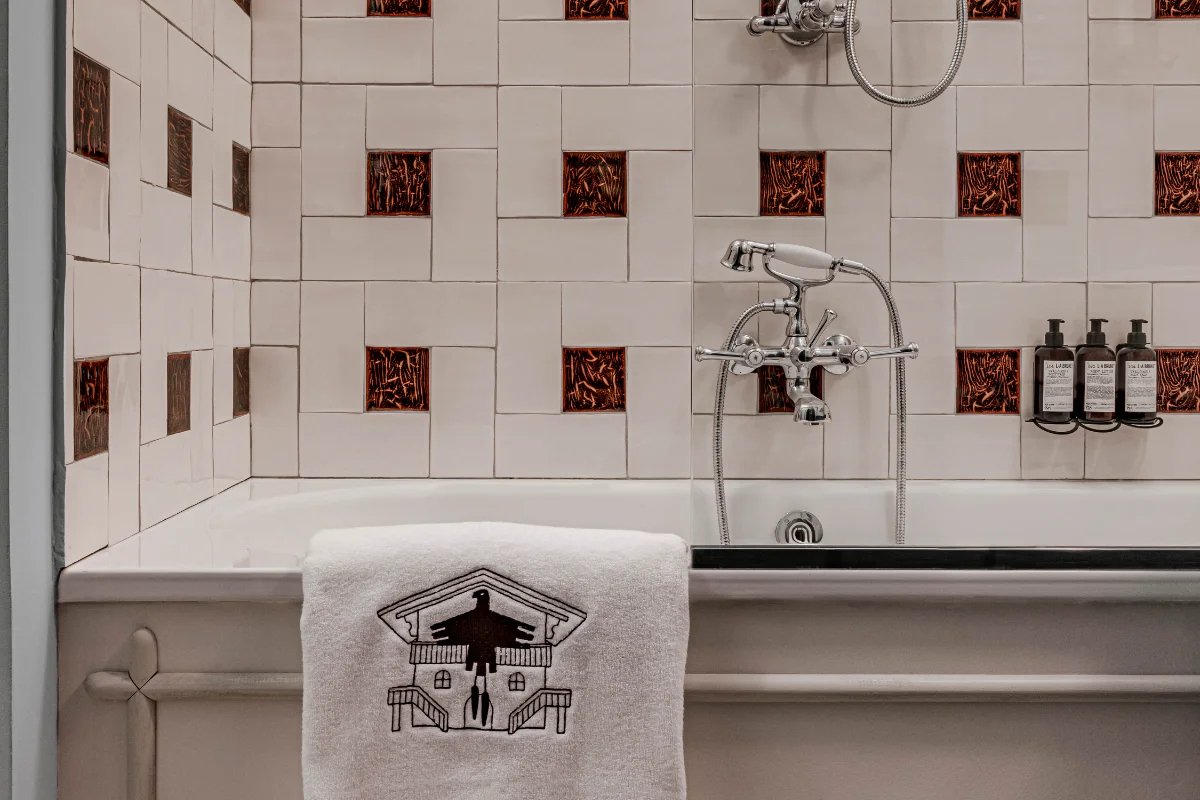 A bathtub with a towel that says ' aesop ' on it