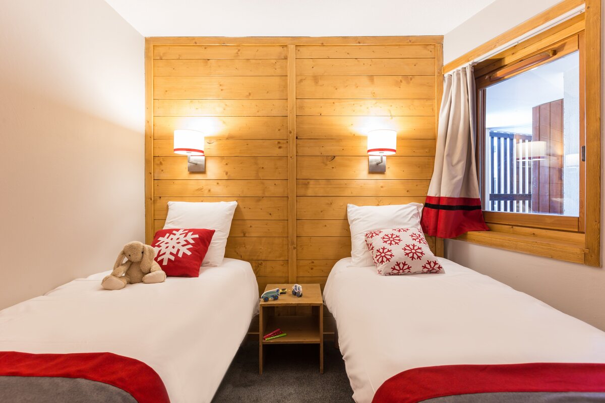 A bedroom with two twin beds and a window