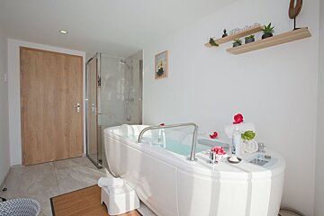 A bathroom with a bathtub and a shelf with the word relax on it