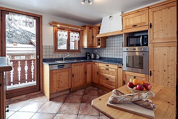 A kitchen with wooden cabinets and a stainless steel oven