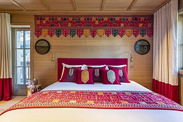 A bed with a red headboard and pillows that say ' i love you ' on them