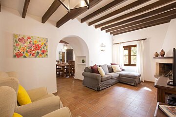 A living room with a couch and chairs and a painting on the wall