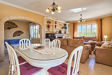 A living room with a dining table and chairs