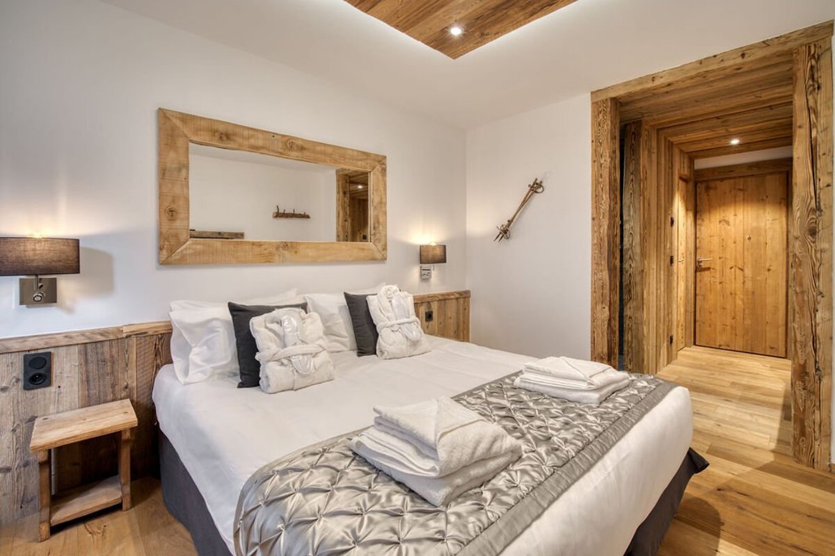 A bedroom with a large bed and a mirror above it