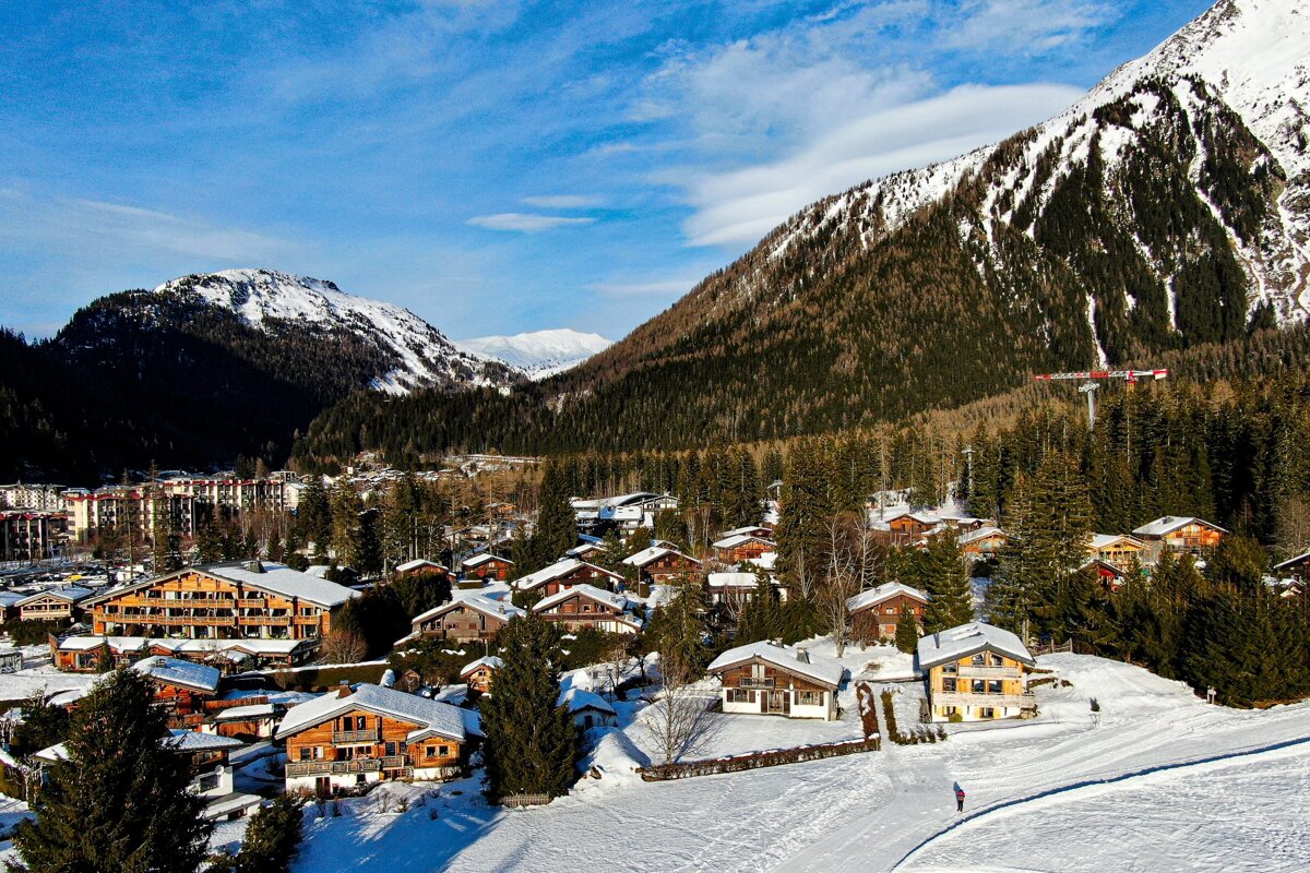 A snowy village with a ski lift in the background