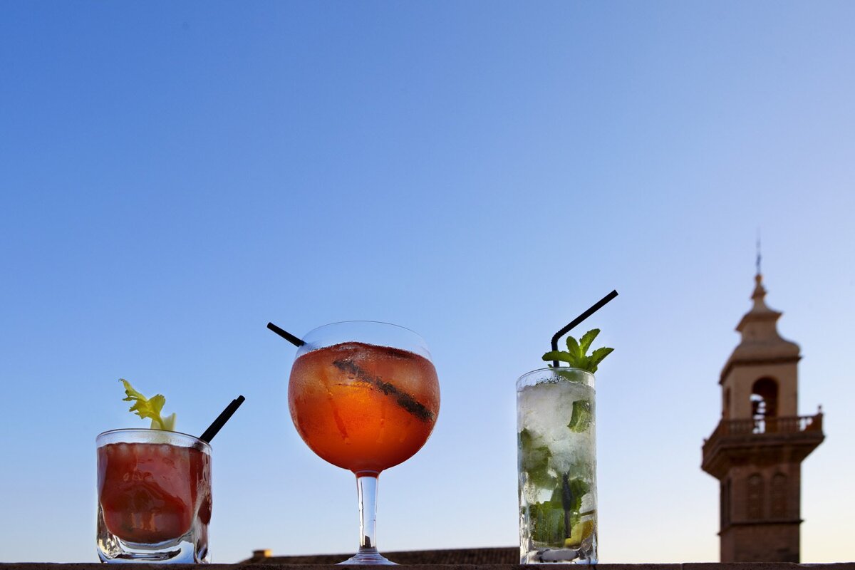Three drinks are lined up in front of a blue sky