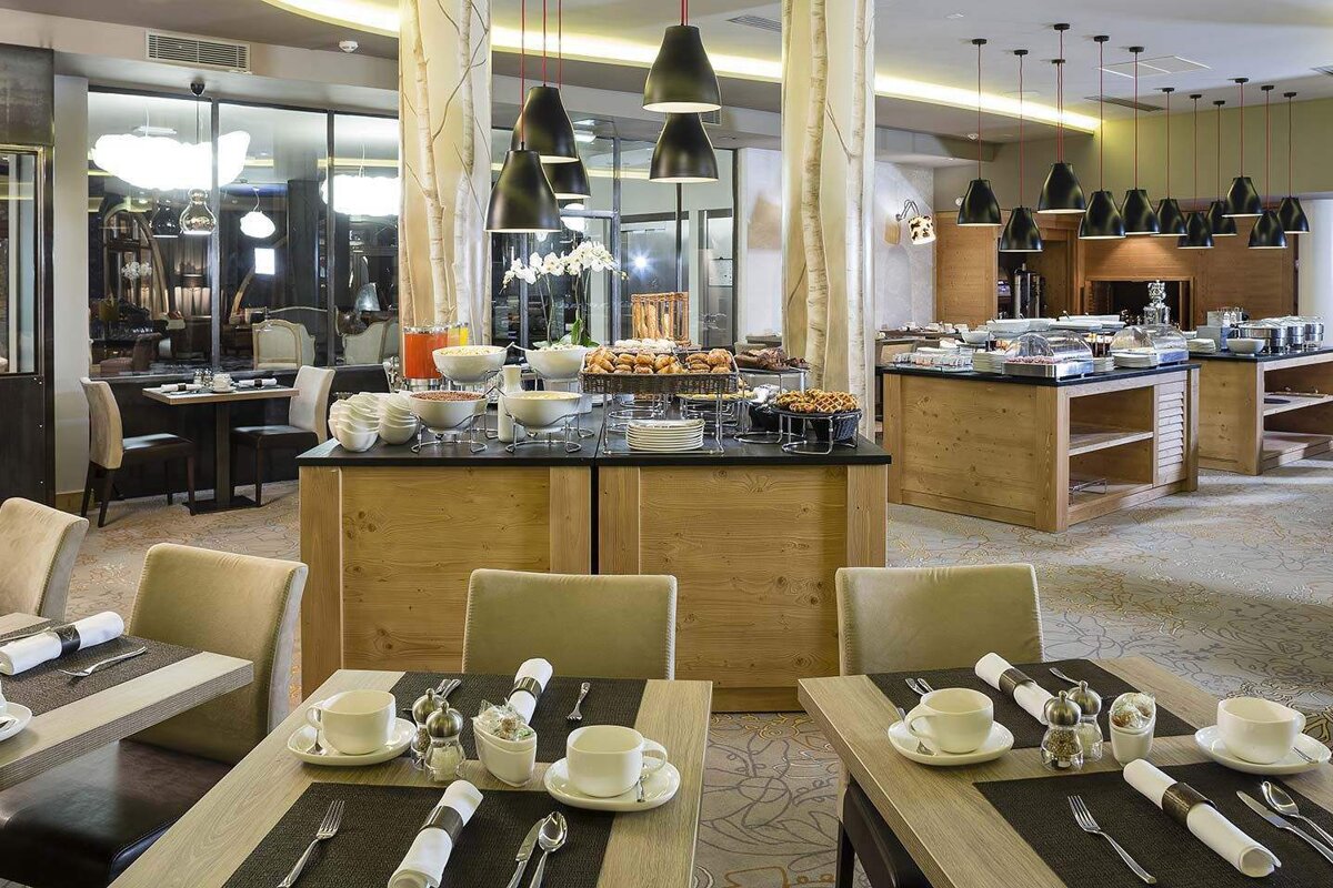 A restaurant with tables and chairs and a buffet
