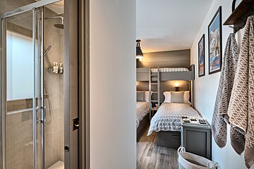 A bedroom with bunk beds and a walk in shower