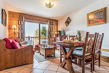 A living room with a wooden table and chairs