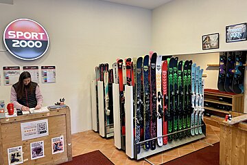 A woman behind a counter in a sport 2000 store