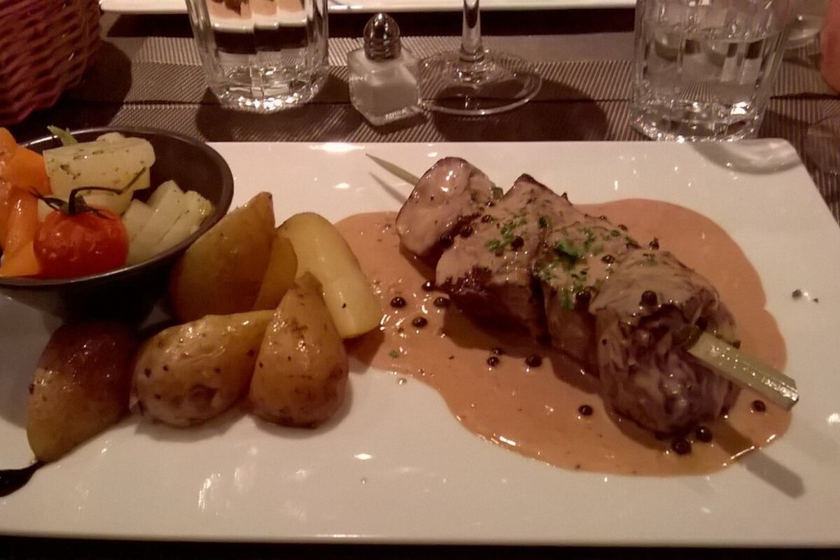 A plate of food with meat and potatoes on a table